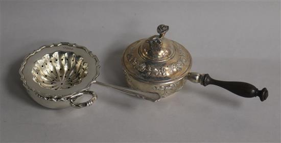 A late 19th century Hanau white metal pan and cover with turned handle, a sliver tea strainer and French white metal taste vin.